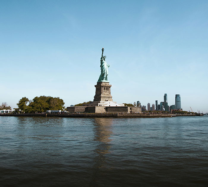 Statue of Liberty with city skyline, highlighting common scams in America theme.