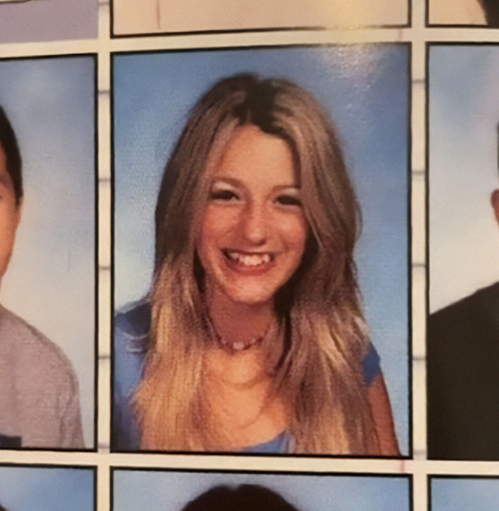 Yearbook photo of a young woman with long hair, wearing a blue top, smiling against a blue background.