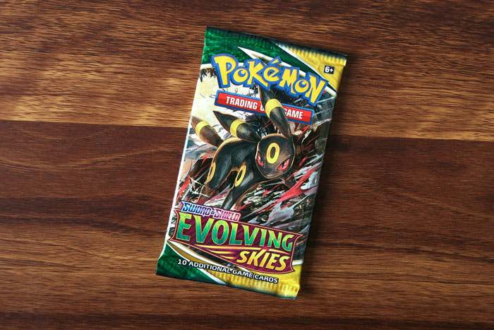 A pack of "Evolving Skies" Pokémon cards gifted for Christmas on a wooden table.