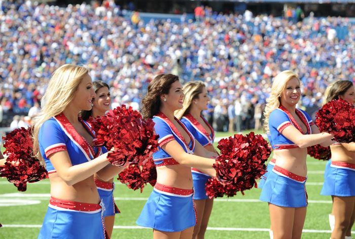 Buffalo Bills cheerleaders performing on the field in blue and red uniforms. Buffalo Bills cheerleaders performing on the field in blue and red uniforms.