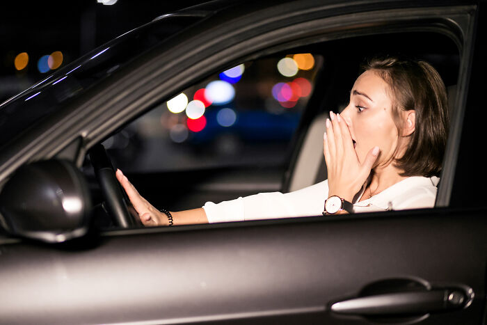Woman driving at night with shocked expression, illustrating everyday things that might seem harmless but could be dangerous.