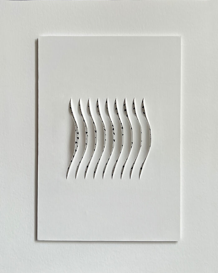 Intricate paper cut design with wavy lines on a white background, showcasing tree-less existence.