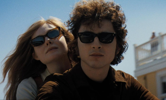 Two people wearing sunglasses, looking relaxed under a clear sky.