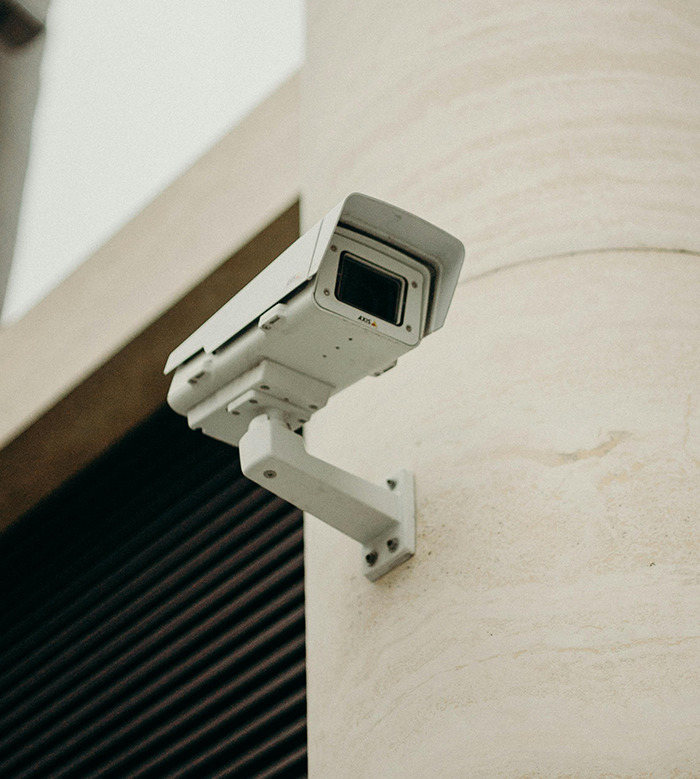 Surveillance camera mounted on a building, representing security concerns.