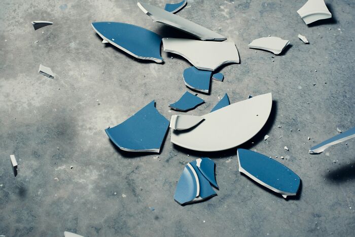 Broken blue and white ceramic pieces on the floor illustrating a savage, revengeful job exit.