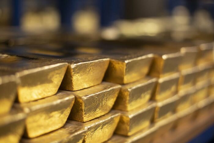 Stacked gold bars in a vault representing hidden facts about history and valuable insights not taught in school.