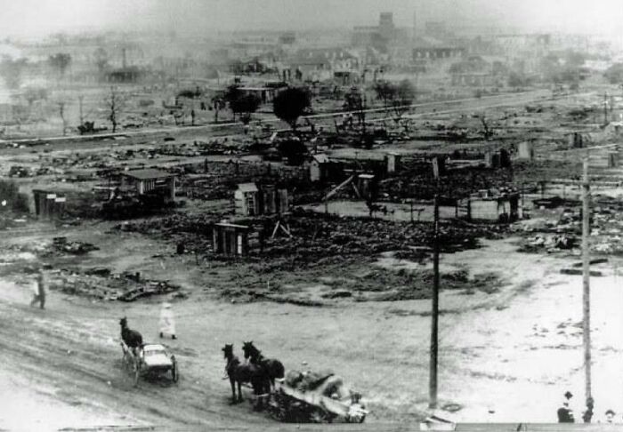 Black and white photo showing a devastated town with ruined buildings and horse-drawn carts illustrating facts not taught in school history.
