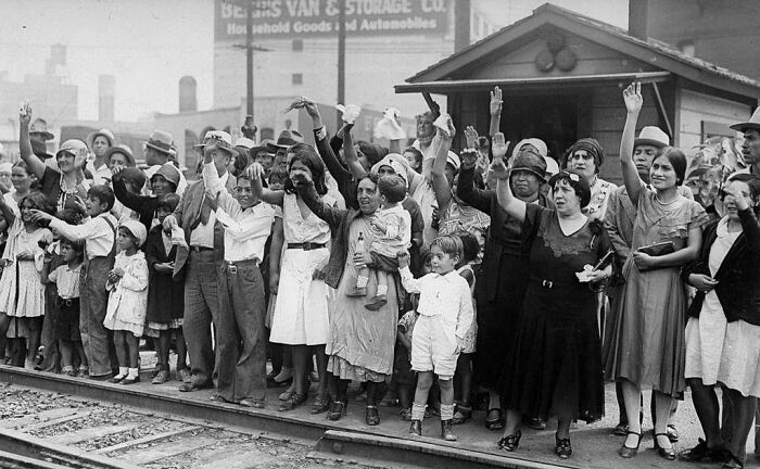 A diverse historical group waving and waiting at a train station illustrating facts not taught in school history.