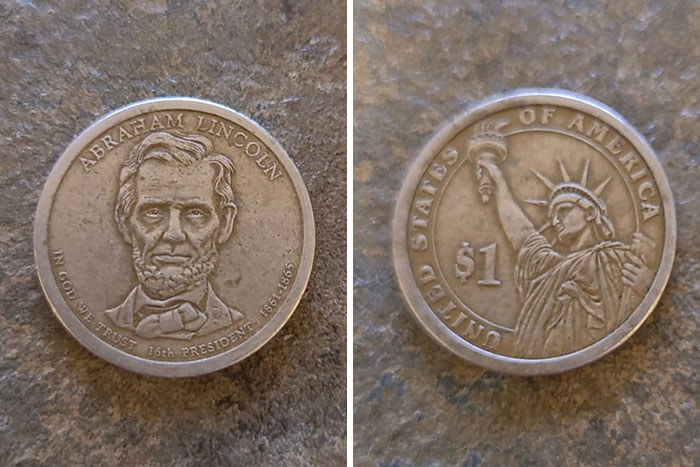 Two collectible coins: Abraham Lincoln portrait on one side, Statue of Liberty and $1 on the other; a numismatist's treasure.