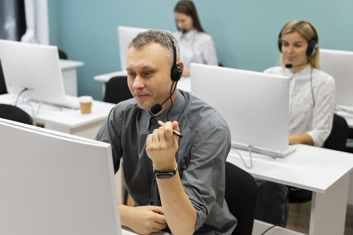 People working remotely on computers with headsets, representing high-paying remote jobs.
