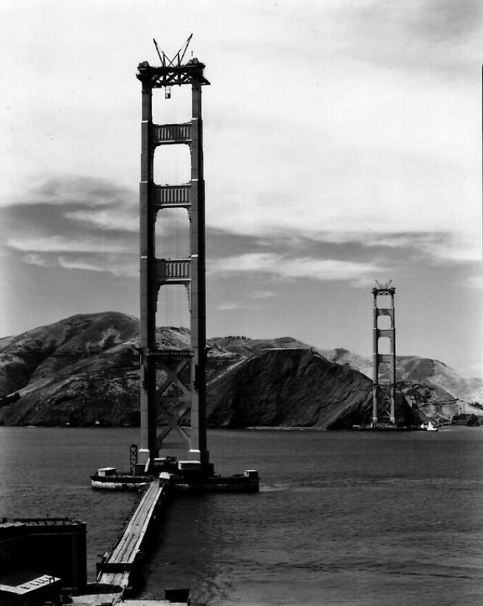 Golden Gate Bridge under construction, showcasing early engineering stages. Fascinating historical architecture in progress.