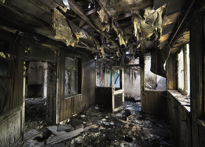 Burned and decayed interior of an abandoned house, evoking horror movie-worthy family secrets atmosphere.