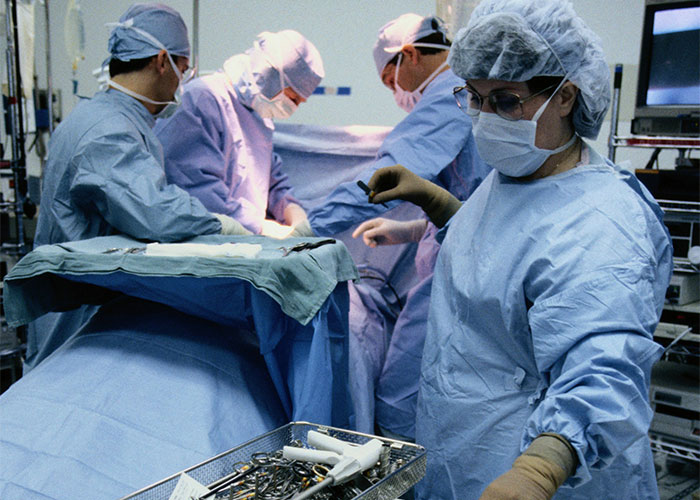Surgeons in an operating room performing a procedure, surrounded by medical instruments, highlighting unsettling medical facts.