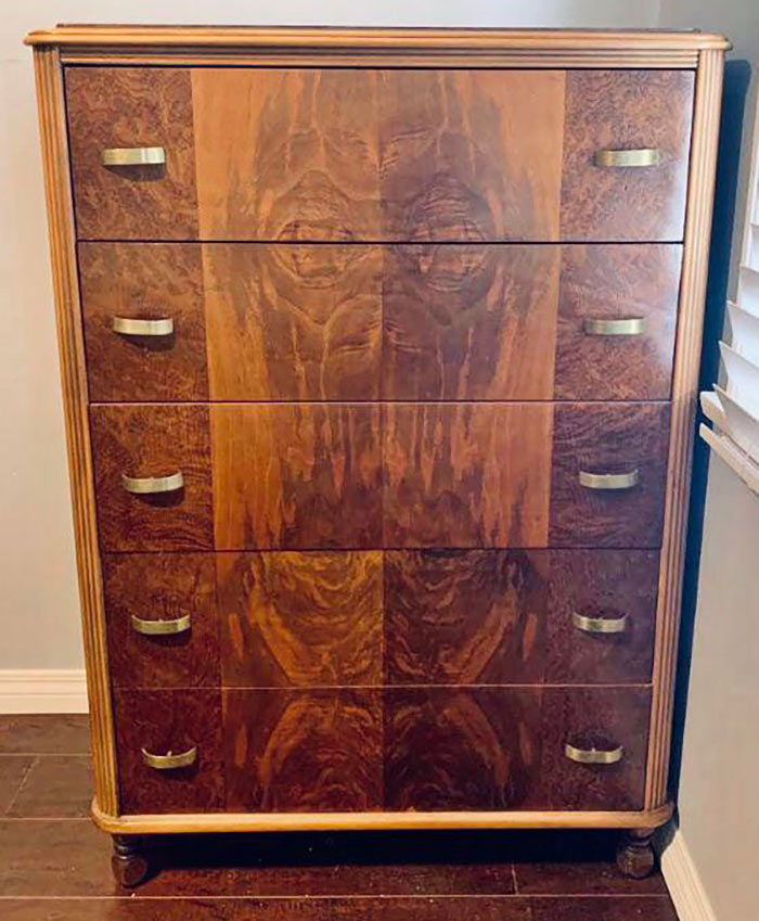 Wooden dresser with an eerie face pattern on the front, highlighting creepy things that sell online.