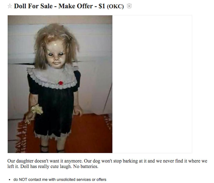 Creepy doll for sale, worn dress, messy hair, unsettling expression.