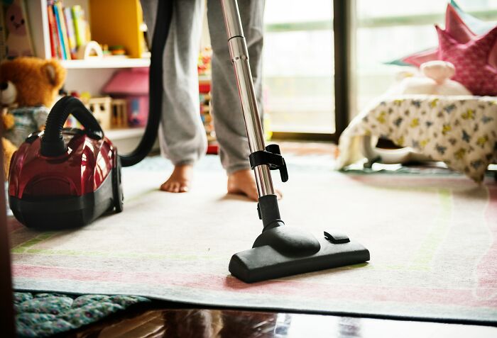 Person using a vacuum cleaner.