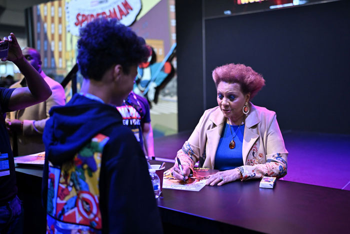 Celebrity autograph signing at comic event, Deadpool cast member Leslie Uggams engaging with fans.