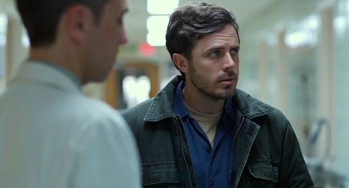 Two men in a dim hallway, depicting a scene from a movie with a sad ending.