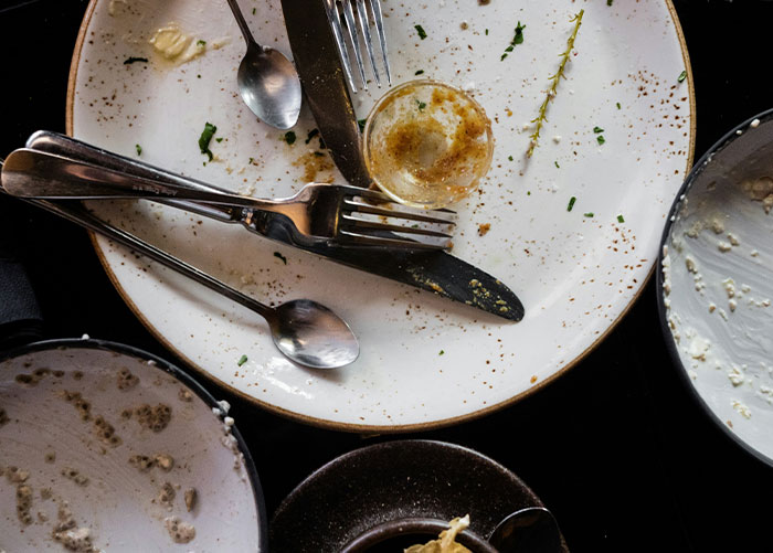 Dirty plates and utensils on a table after dine and dash experience.