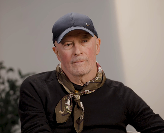Director of 'Emilia Pérez' wearing a cap and a scarf, with a plant in the background. Director of 'Emilia Pérez' wearing a cap and a scarf, with a plant in the background.