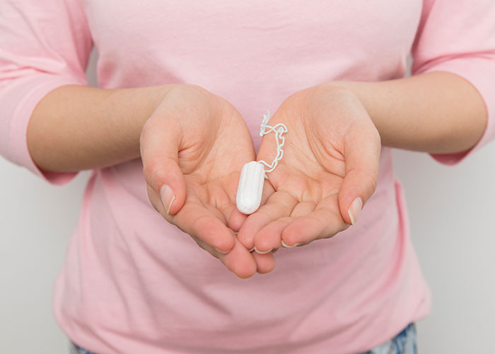Hands holding a tampon, highlighting a common topic often subject to mansplaining.