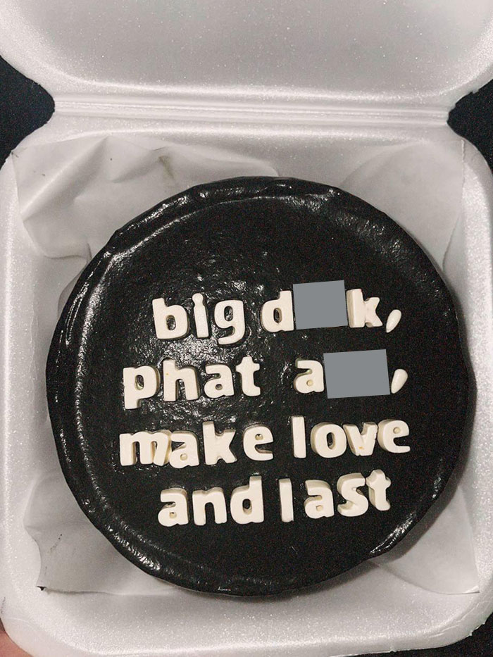Black cake with cheeky message in white icing; a funny-wholesome-anniversary-surprise in a takeaway box.