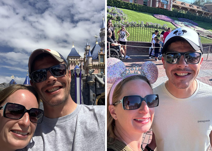 Couple enjoying a funny wholesome anniversary surprise at a theme park, wearing sunglasses and smiling.