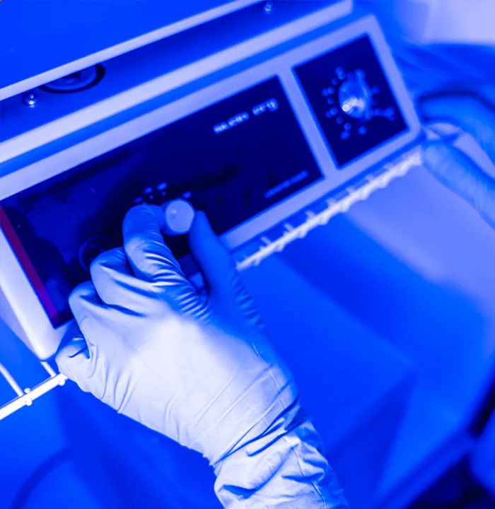 Gloved hands adjusting a cryogenic machine, highlighting the "freeze bodies" process for future revival.