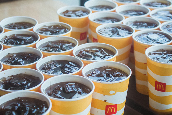 Numerous McDonald's soft drinks in paper cups, highlighting cultural insights from a German perspective.