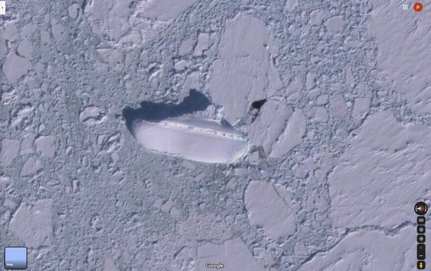 Strange object found on Google Earth resembling a ship, surrounded by c*****d ice and snow.