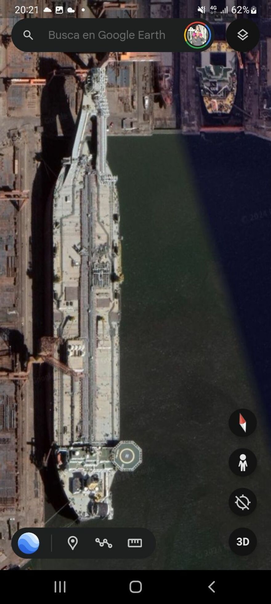 Aerial view of a large ship docked at a port found on Google Earth.