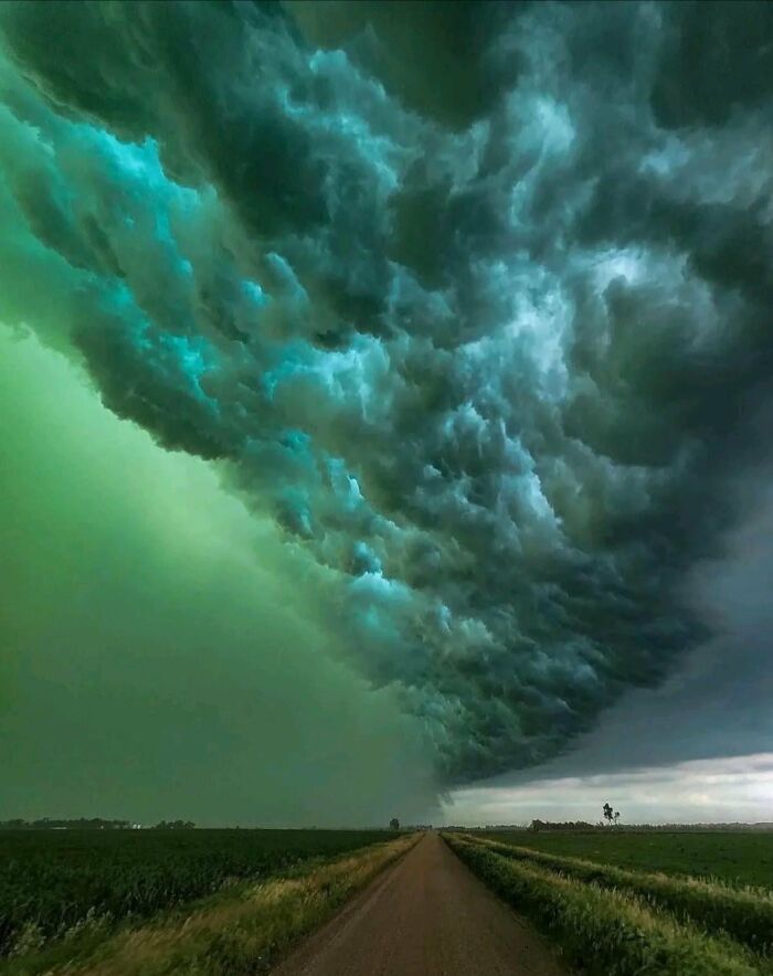 Dramatic storm clouds over a rural road, highlighting nature disaster resilience.