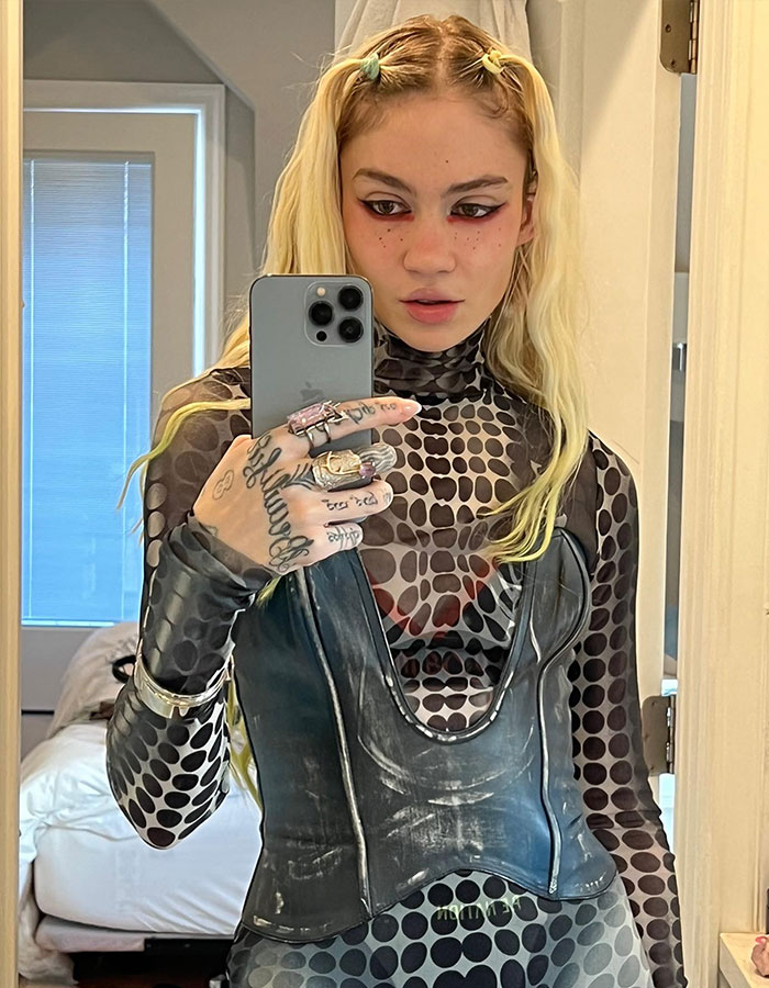 Musician Grimes takes a mirror selfie, wearing a patterned outfit, amid controversy. Musician Grimes takes a mirror selfie, wearing a patterned outfit, amid controversy.