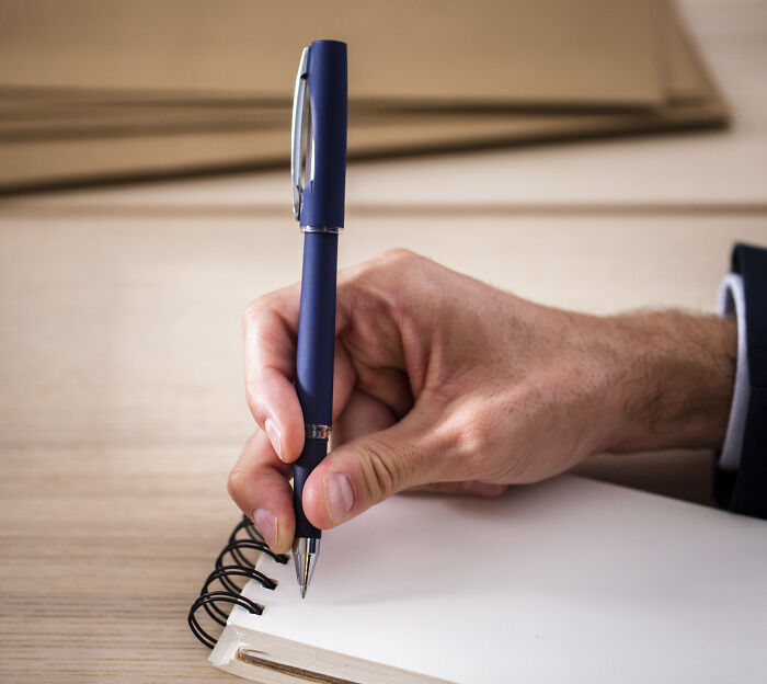 A hand writing in a notebook.