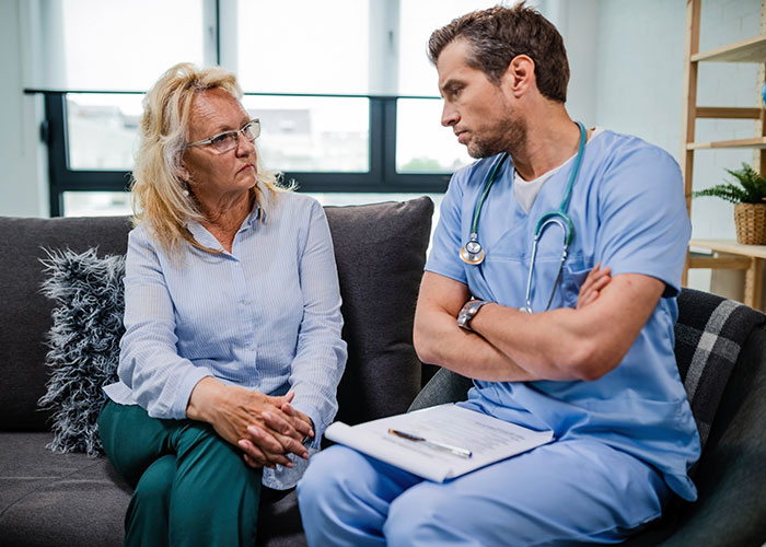 Doctor and patient in serious conversation on a couch, highlighting normal things that seem horrific upon reflection.