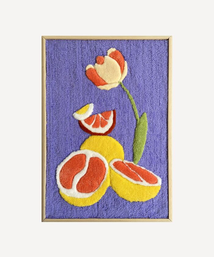 Tufted artwork featuring vibrant citrus fruits and a tulip on a purple background.