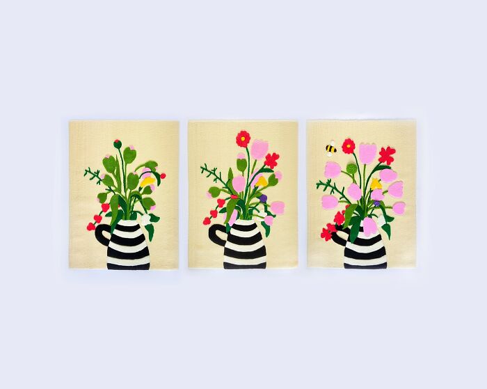 Tufted artwork featuring colorful floral designs in striped vases by Cléa Delogu, showcasing vibrant and intricate patterns.