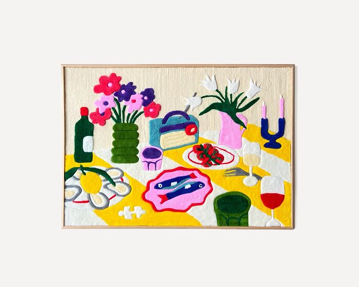 Colorful tufted artwork depicting a vibrant still life with flowers, tableware, and food.