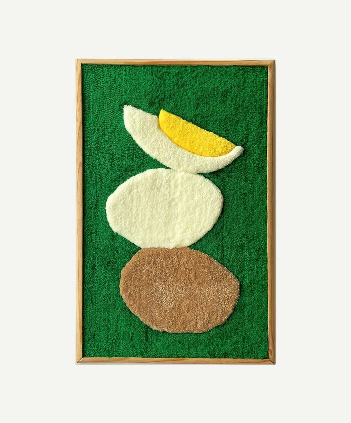 Tufted artwork depicting abstract shapes in green, yellow, and brown on a green background by Cléa Delogu.