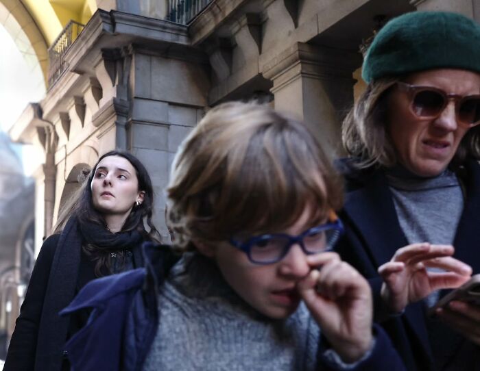 Street photography scene with people walking, capturing candid urban moments.