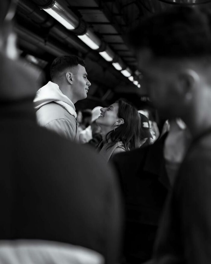 Couple sharing a moment on a bustling street, with candid expressions captured in pure street photography style.