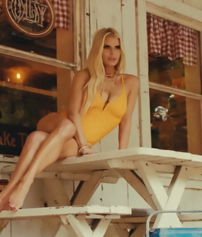 Blonde woman in yellow swimsuit sitting on a wooden table, showcasing revenge body outdoors. Blonde woman in yellow swimsuit sitting on a wooden table, showcasing revenge body outdoors.