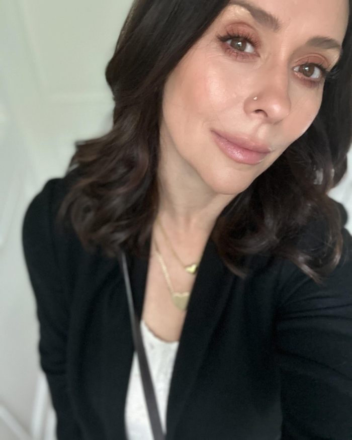 Person with dark hair, wearing a black jacket, looking at the camera.