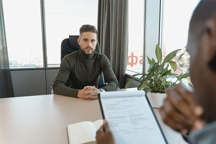 Job interview scene, recruiter reviewing candidate's resume, focusing on potential red flags.
