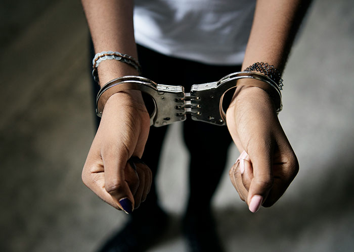 Person with hands cuffed, symbolizing strange human behavior in courtrooms.