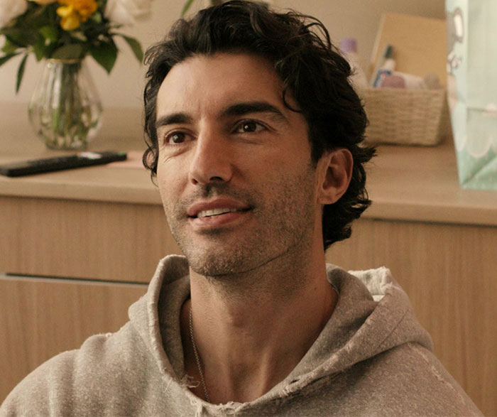 Man in a casual setting, wearing a gray hoodie, related to Blake Lively and Justin Baldoni text exchange news.