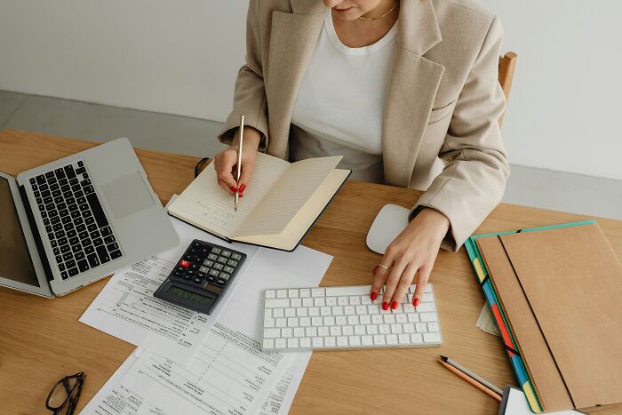 Person working remotely with a laptop and documents, illustrating high-paying remote jobs in a home office setting.