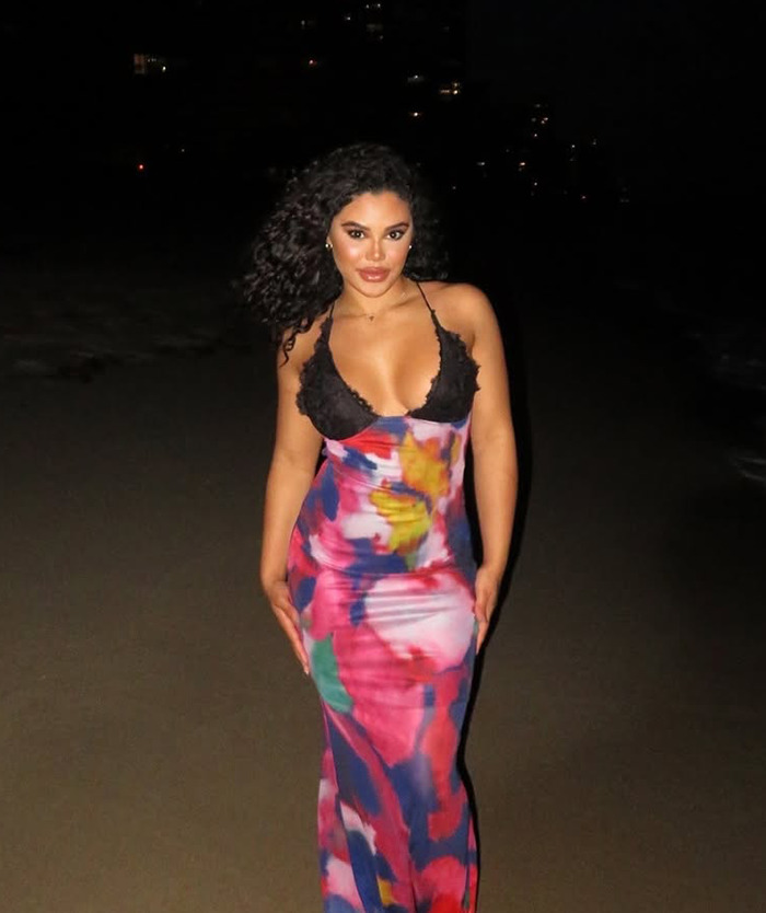 Kaya Odom in colorful dress on beach at night.