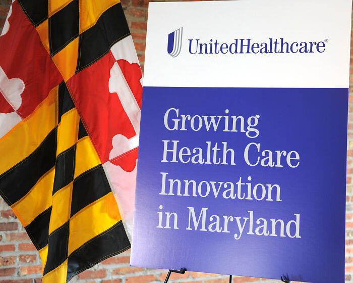 UnitedHealthcare sign with flag, highlighting healthcare innovation in Maryland, related to false advertisements.
