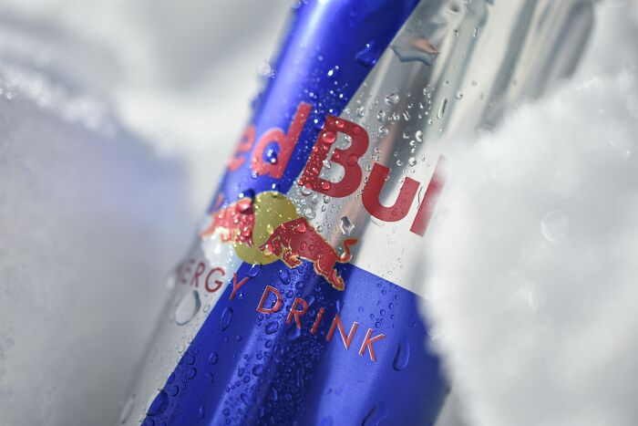 Energy drink can in snow, possibly symbolizing false advertisements by companies.